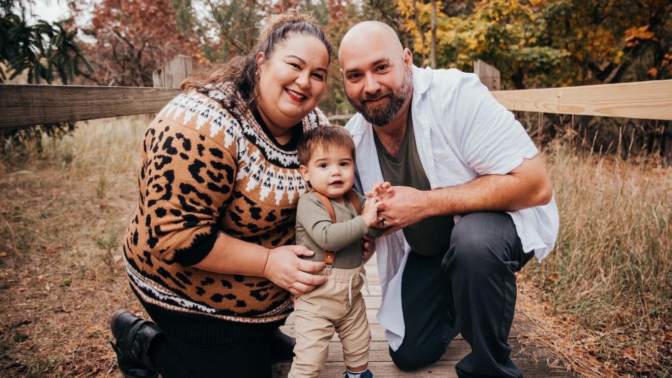 Hokulani poses for a family photo outside with her husband and her son.