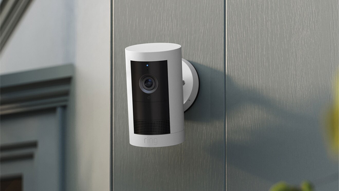 ホワイトのセキュリティカメラ。屋外の壁に設置されている。