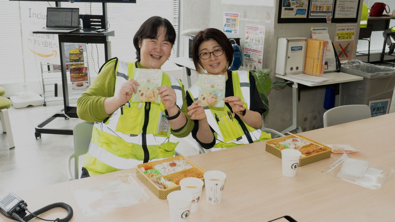 2人の女性はカラフルな袋に入ったクッキーを見せている。