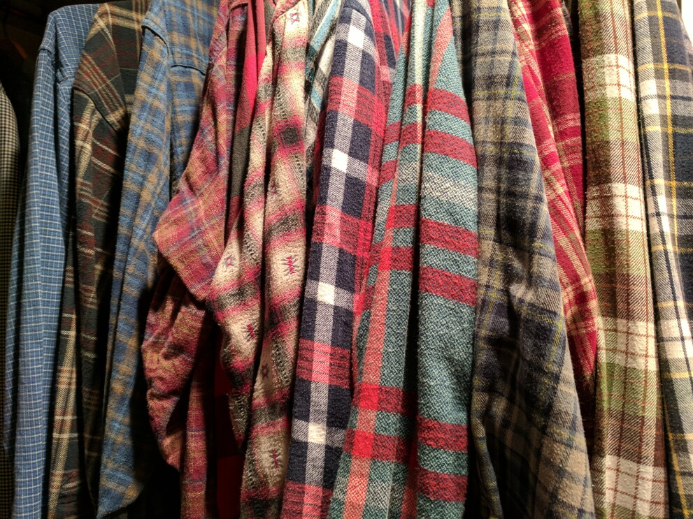 A row of flannel shirts, hanging in a closet