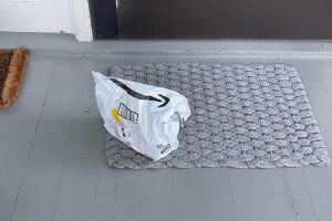 An Amazon packaged sits in front of a doorstep.