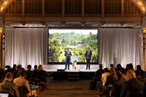 A photo of AWS Vice President Swami Sivasubramanian and Dr. Kingsley Ndoh, founder of Hurone AI, speaking on stage at an UN summit on generative AI.