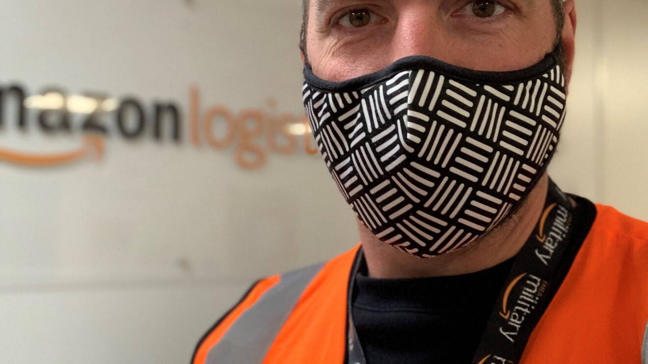 Amazon employee wearing  a mask and orange high vis vest 