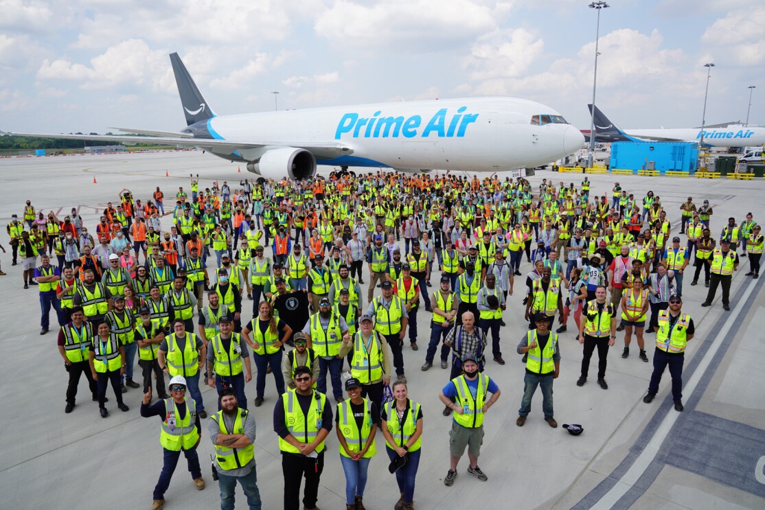 An image of more than 100 employees wearing their safety vests while standing in front of a Prime Air plane at the Kentucky Air Hub.