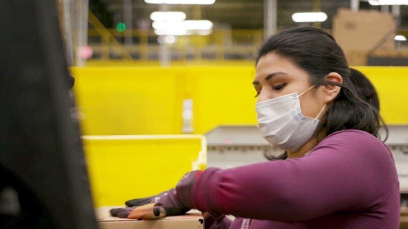 Amazon employee performing work duties while wearing a mask during the COVID-19 pandemic.