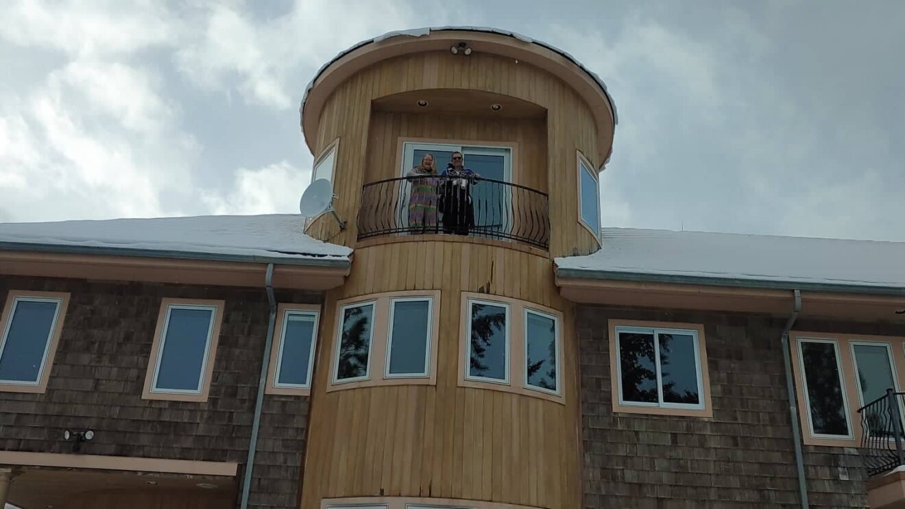 Rikke and Truls look down from their third-floor balcony.