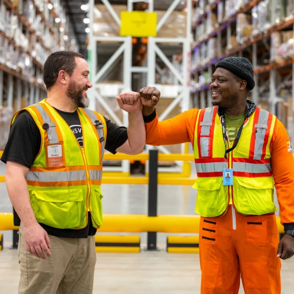 two amazon employees fist bumping 