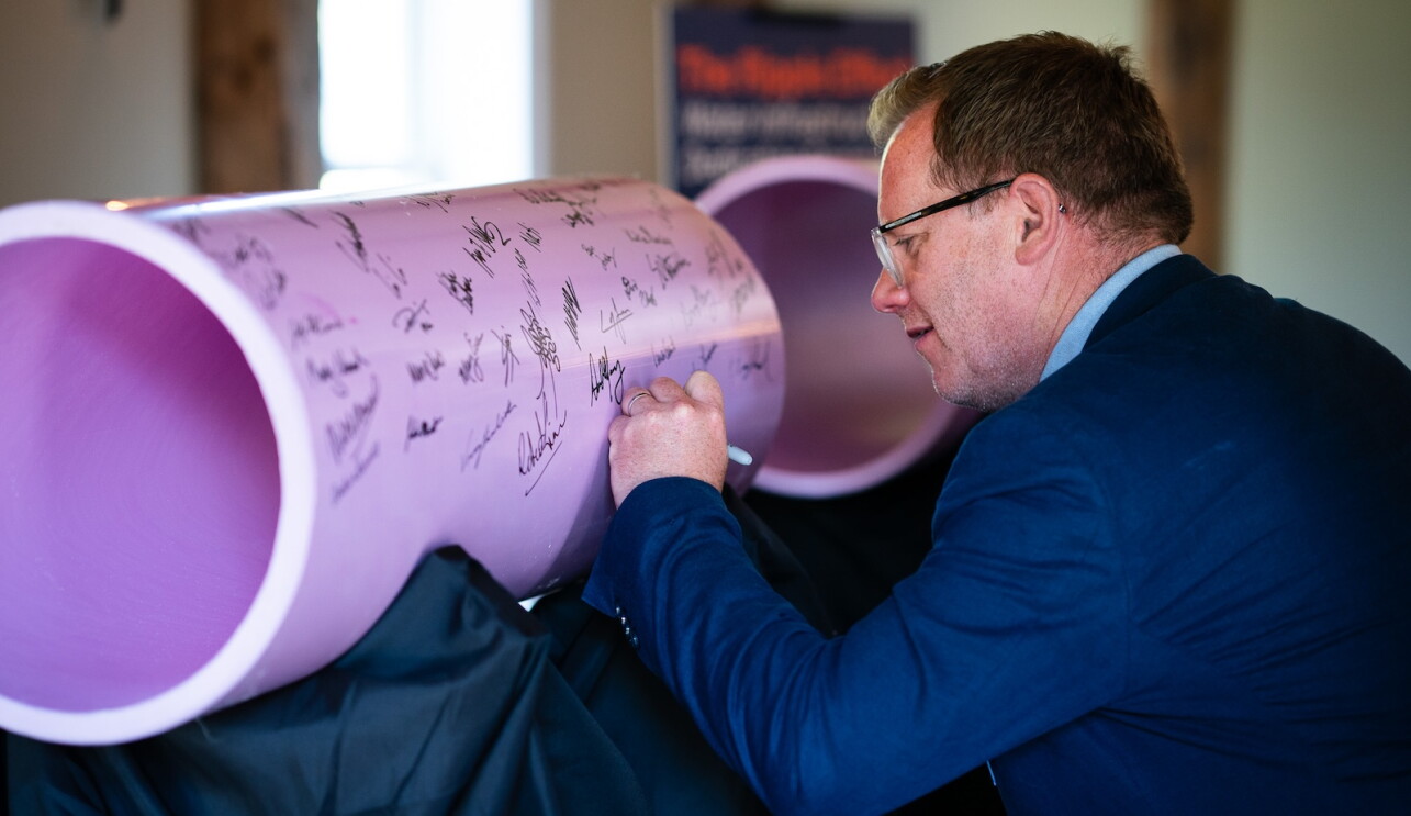 A representative makes a ceremonial signature.