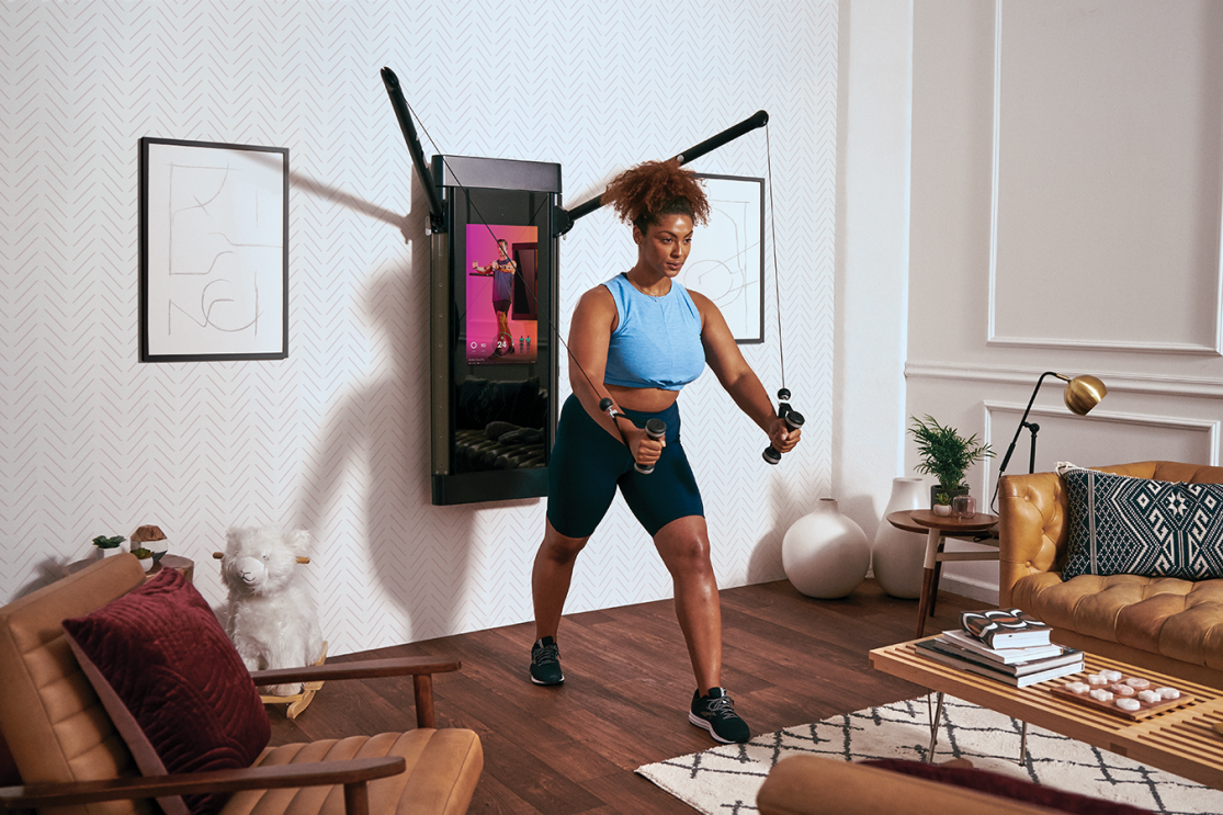 A woman exercises in her living room.