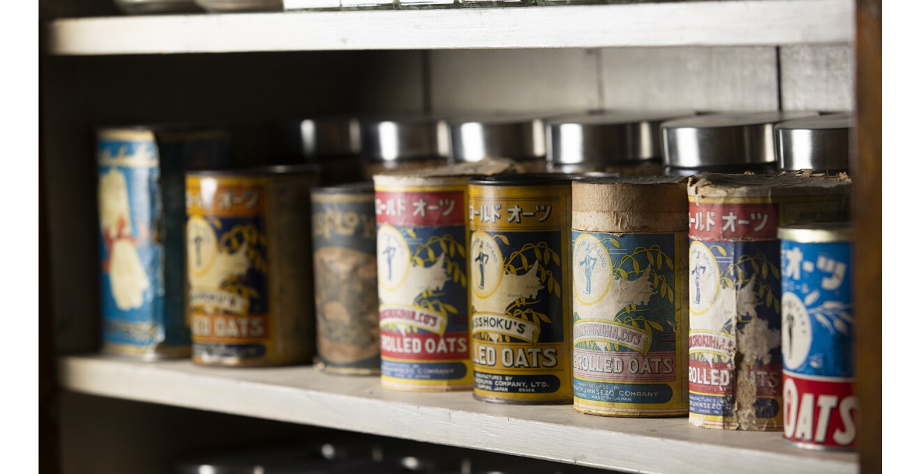棚におさめられた色褪せた昔の缶のパッケージたちの写真。