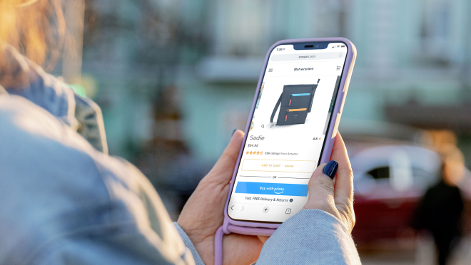与海军指甲油一位妇女抱着手机在浏览从Sherpani crossbody袋。