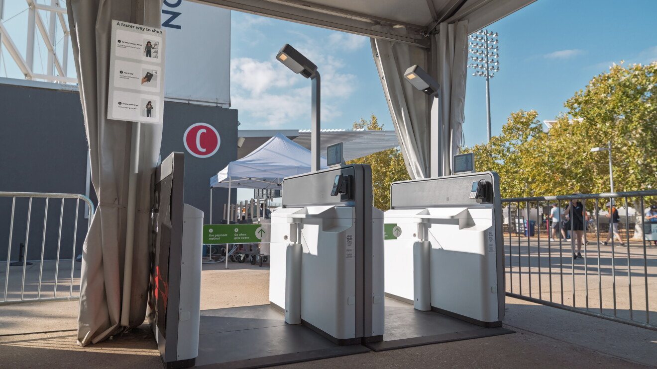 Entrance gate scanners at outdoor event with instructions poster