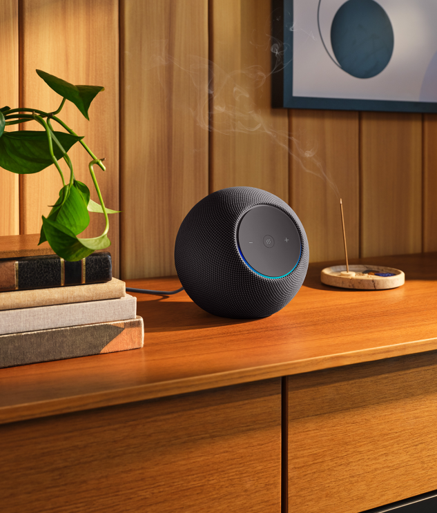 Image of an Echo Studio on a wooden desk beside a burning incense stick