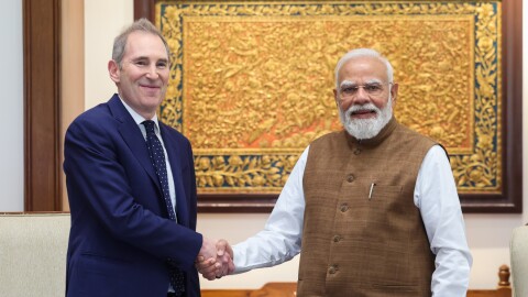 Amazon CEO Andy Jassy and India Prime Minister Modi shaking hands in front of ornate golden artwork during official meeting
