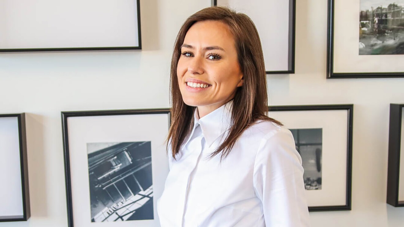 A woman looks at the camera in a general home environment.