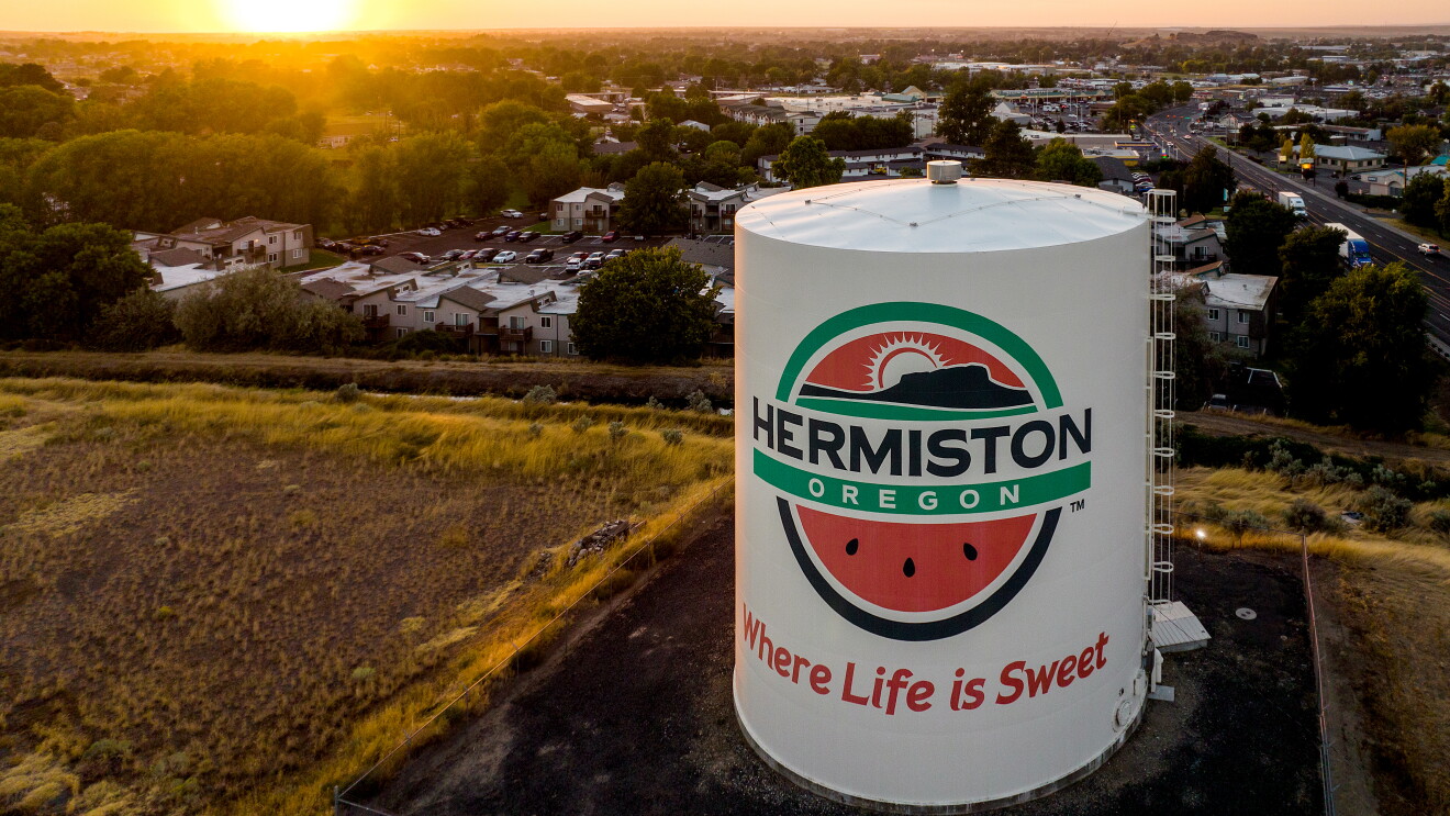 Hermiston Oregon water tower with logo featuring watermelon and tagline Where Life is Sweet at sunset
