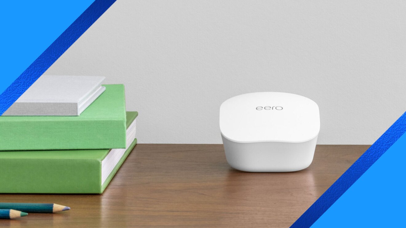 eero mesh WiFi router on wooden desk with books and pencil