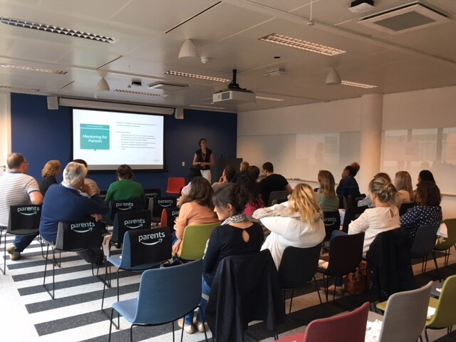 Amazon Parents Mentoring session for Amazonians. A room of employees listening the presenters on the topic.  