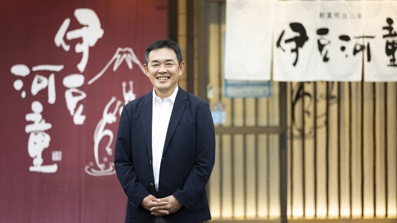 店舗の前で、笑顔の栗原さんの写真