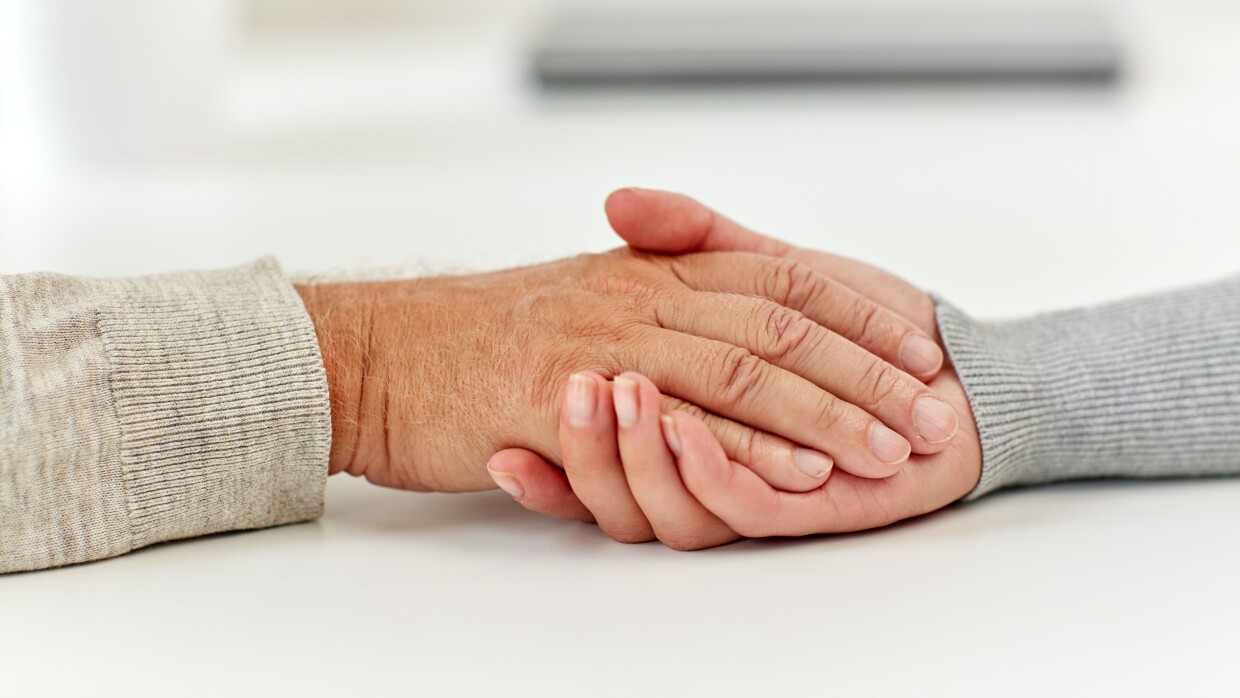 close up of old man and young woman holding hands