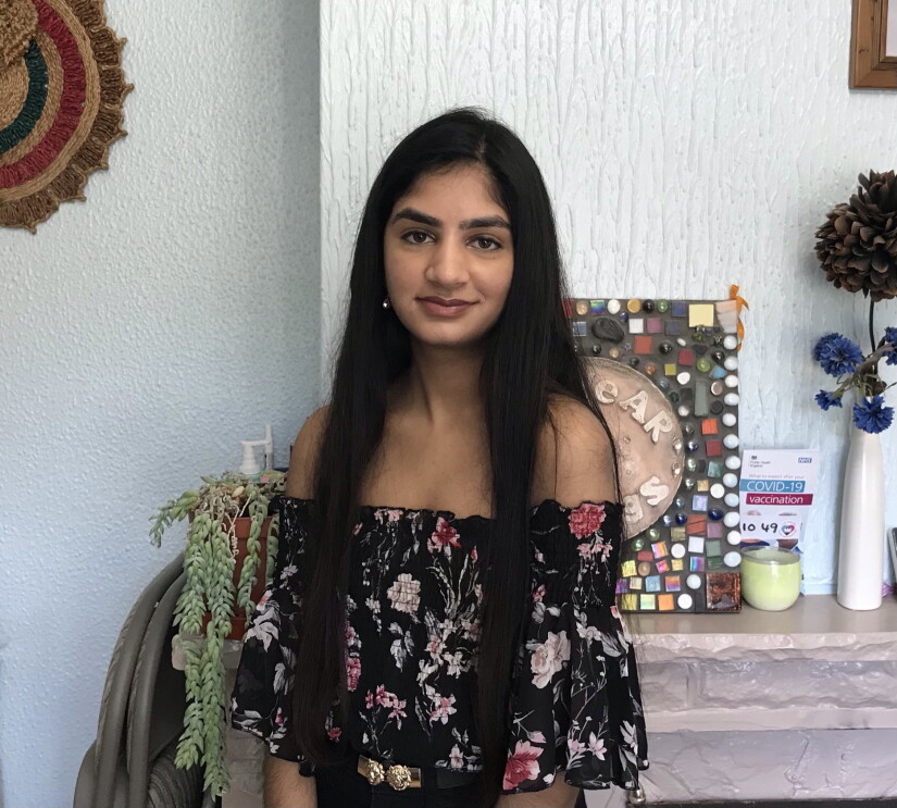 Riddhi Patel standing in front of her fireplace