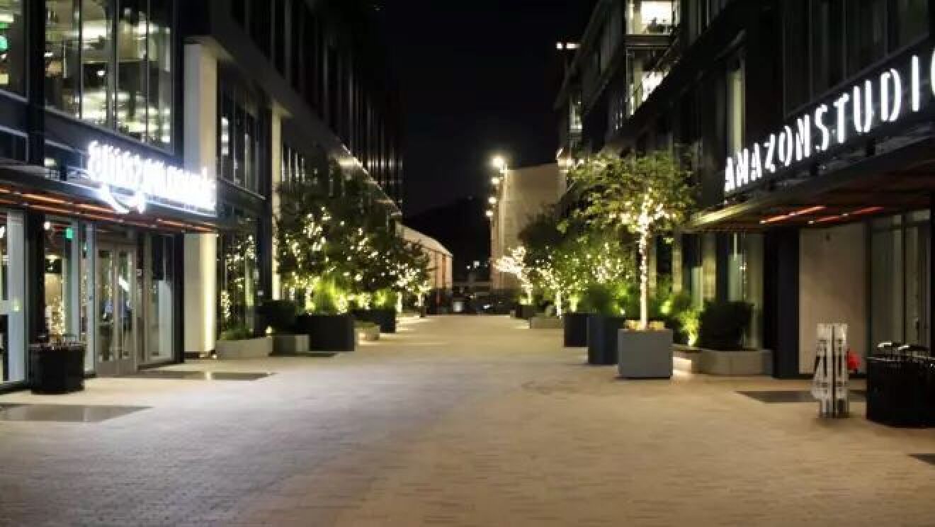 建物と建物の間の通り沿いがライトアップされている。建物の入り口にはネオンサインが光っている。