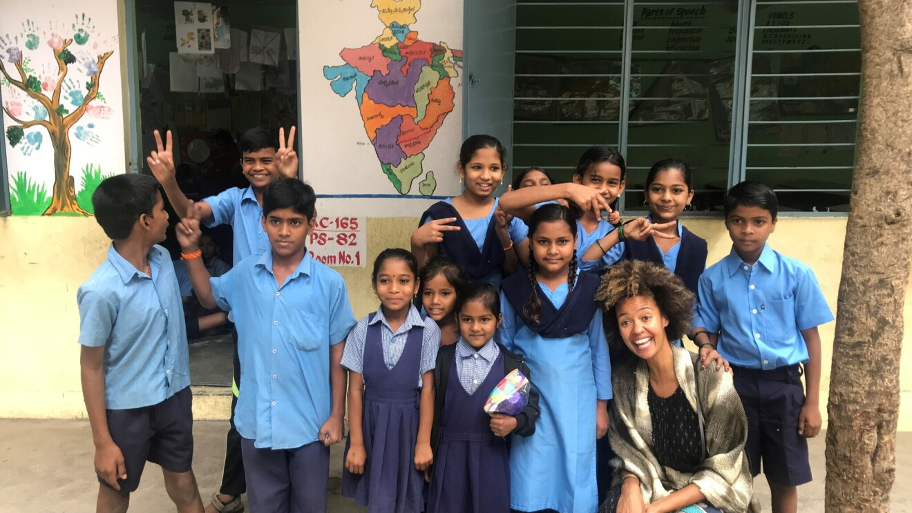 A group of 12 schoolchildren in Bangalore, India pose with an Amazon employee