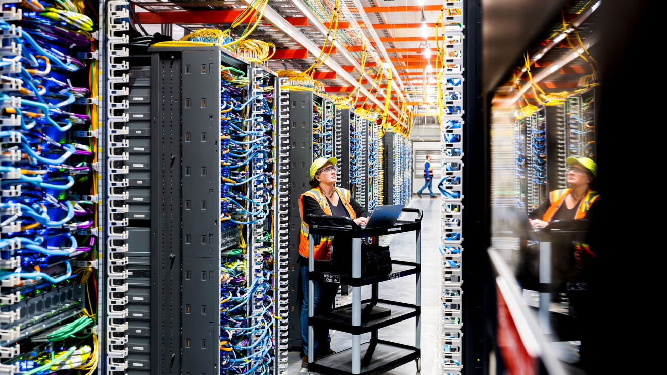 An Amazon data center technician works on a laptop
