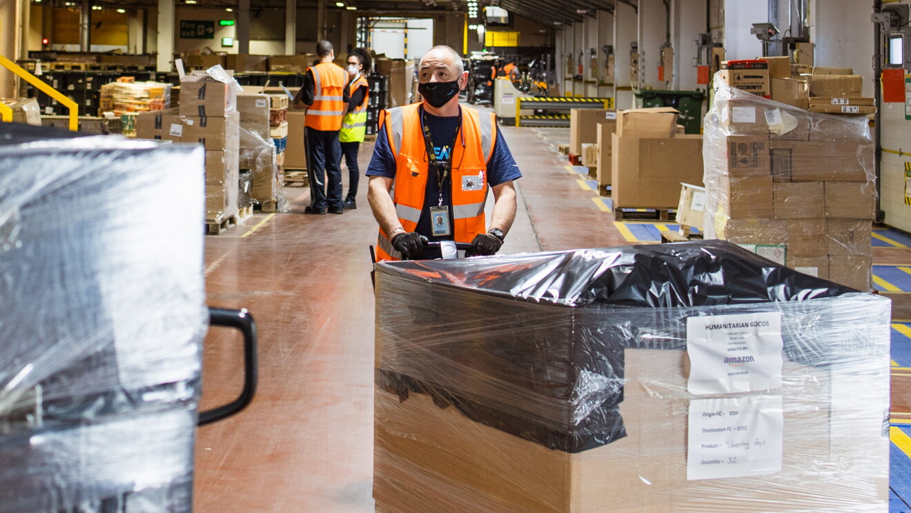 Dipendenti Amazon movimentano pallet con i beni donati a favore dei rifugiati ucraini nell'hub umanitario in Slovacchia