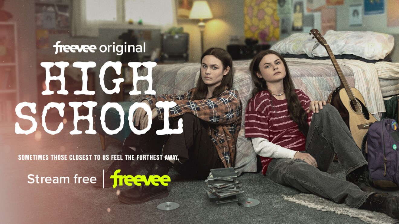 An image of two teens leaning against a wall sitting on the floor and looking at the camera. Text on the image says "Freevee Original High School Stream Free Freevee"