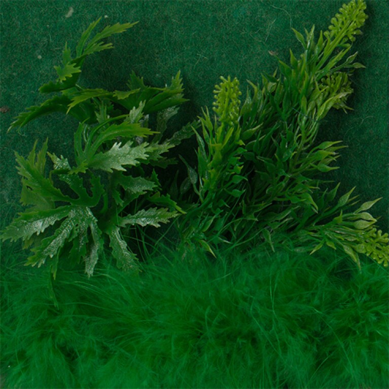 Plastic green foliage and a feathery green object are set against a green background.