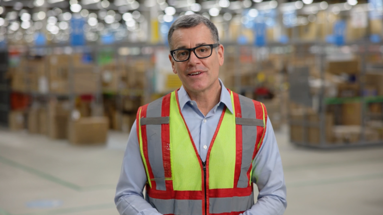 Doug Herrington, CEO of Worldwide Amazon Stores, in fulfillment center wearing safety vest
