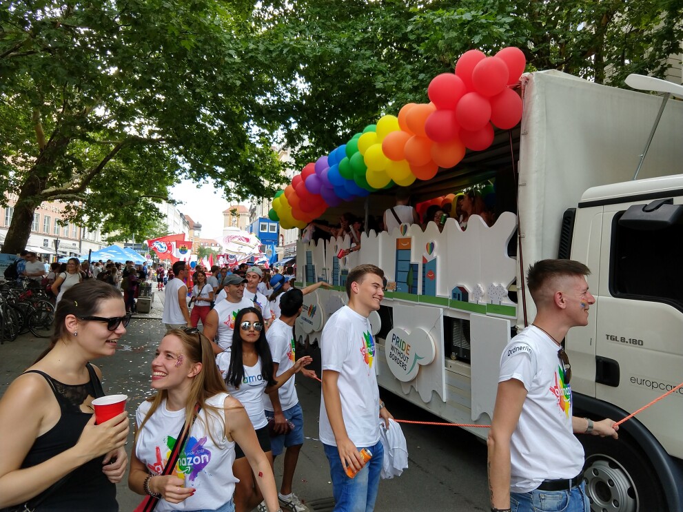 Amazon Mitarbeiter feiern neben dem Glamazon-Wagen auf dem Christopher Street Day in München.