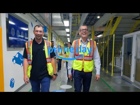 An Amazon employee walks alongside Amazon Stores CEO Doug Herrington