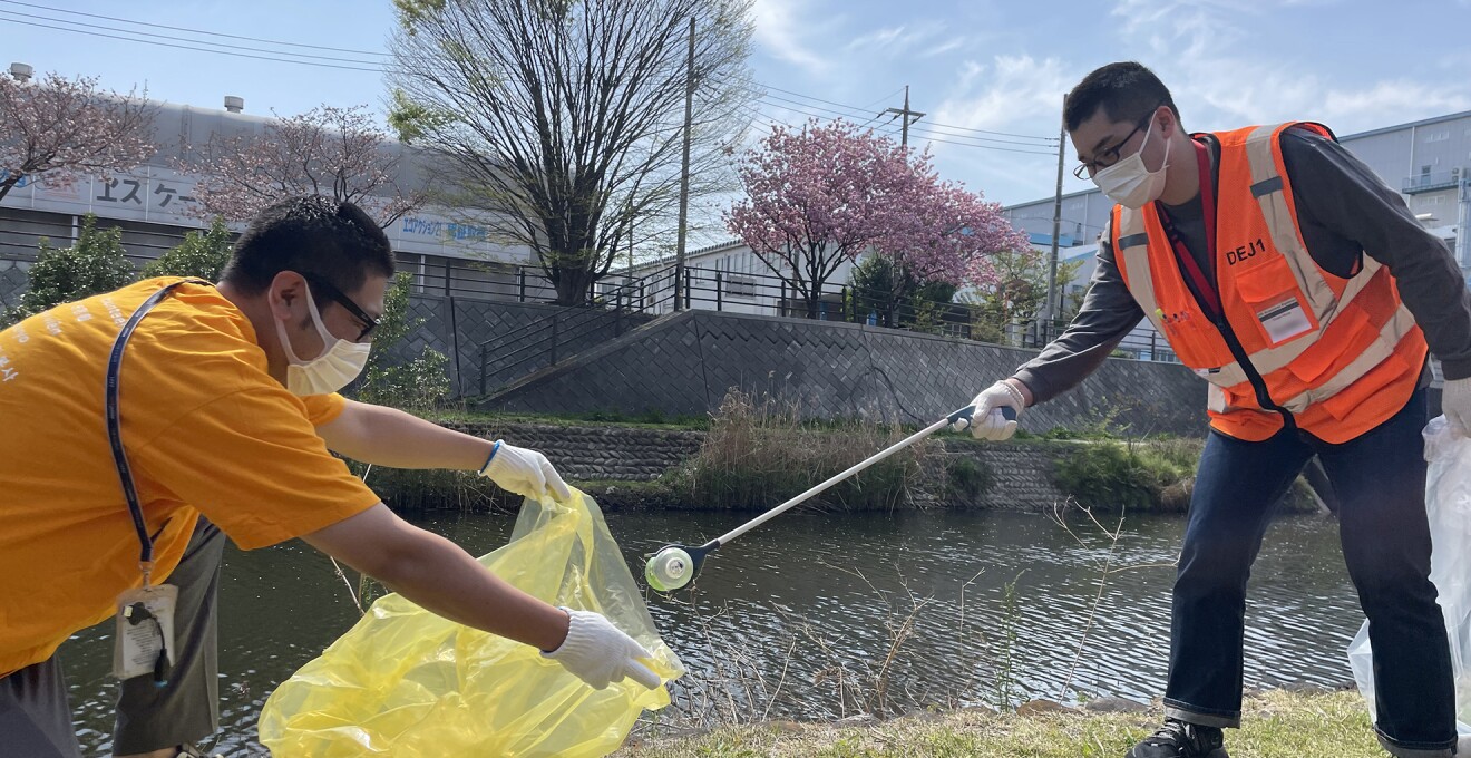 河原でゴミ拾いをしているメンバーの写真