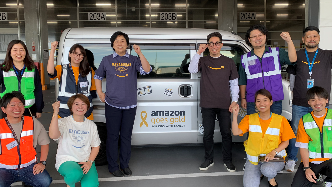 「amazon goes gold」と描かれデコレーションされた配送者を囲む社員たち