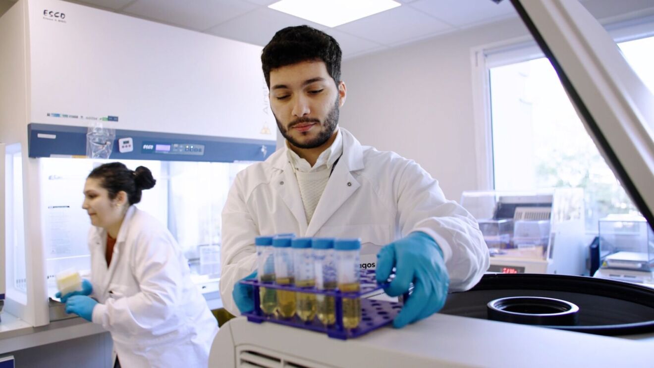Scientists in lab coats handling test samples