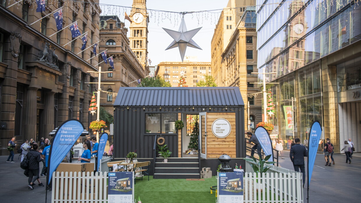 A tiny house set up in a city street for display.