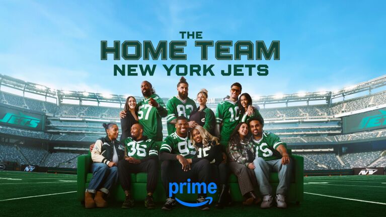 Promo art for 'The Home Team: New York Jets' with six members of the team and their partners on a couch with the stadium behind them.