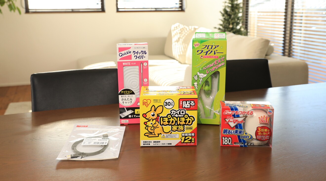 テーブルに置かれたクイックルワイパー、貼るカイロ、電子式蚊取り線香、パソコンのケーブル