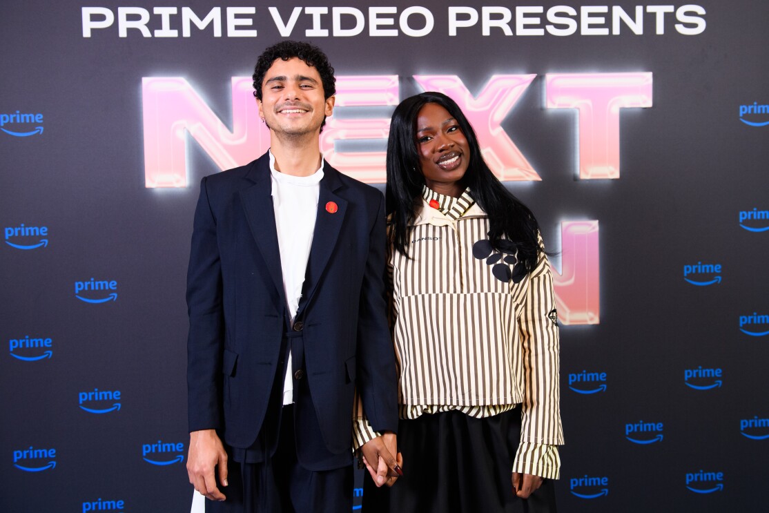 A man and a woman in front of a prime video branded backdrop