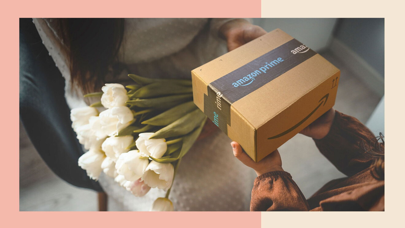 A child hands an unopened Amazon box to a woman sitting in a chair with a bouquet of flowers on her lap.