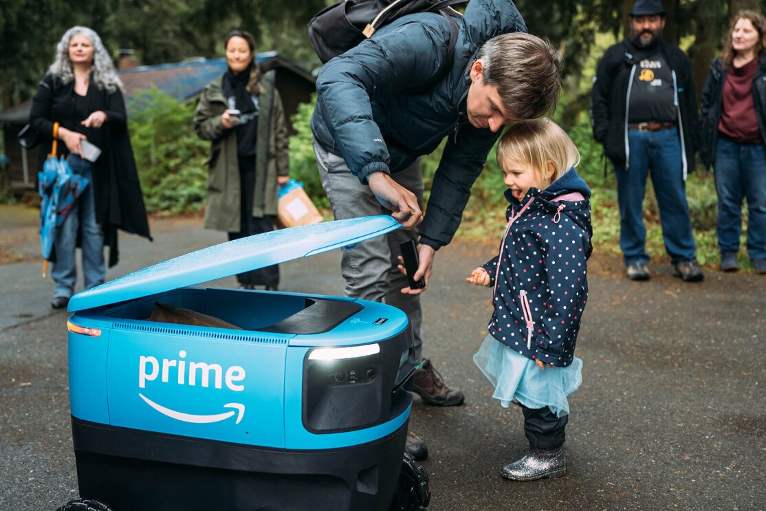An image of the Amazon Scout robot engaging with families at an event.