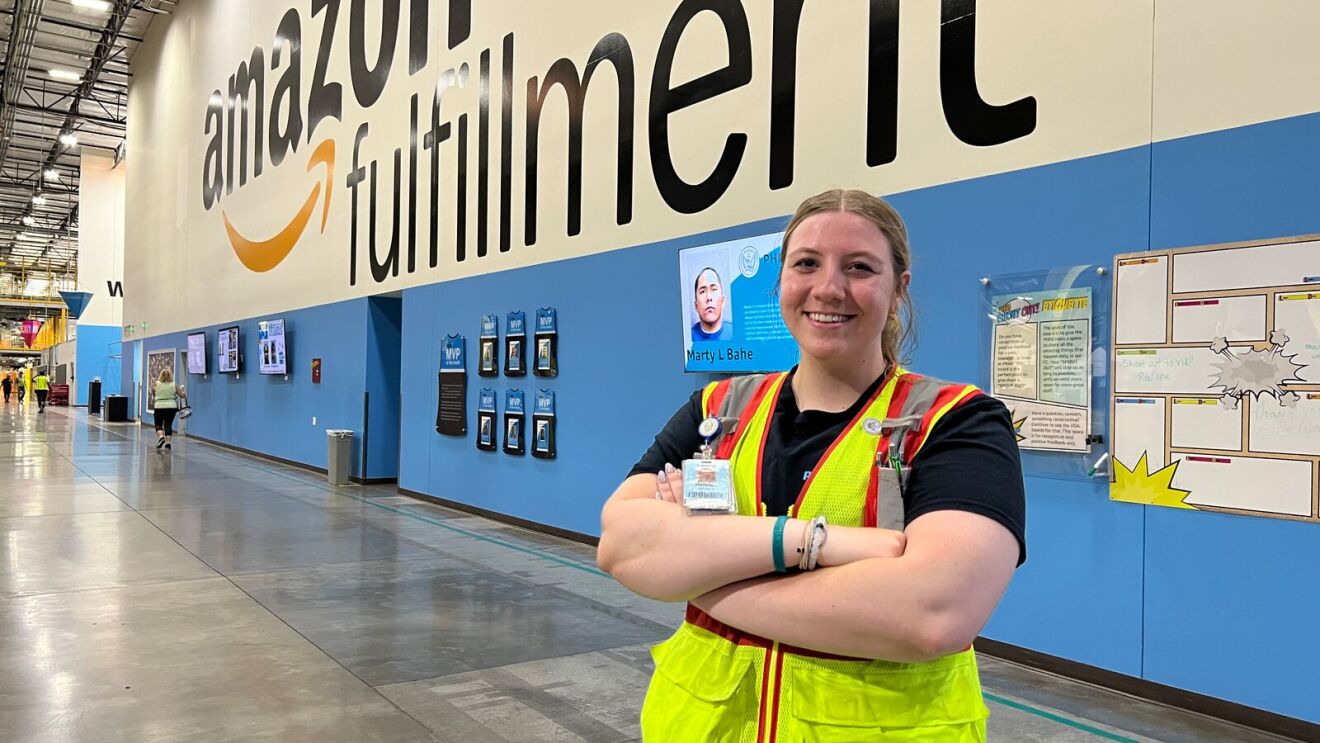 Amazon fulfillment center employee in safety vest standing confidently