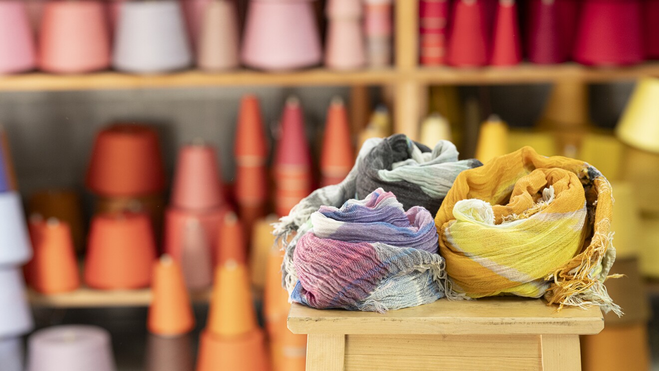 カラフルな糸巻の前に置かれた柔らかそうなショール