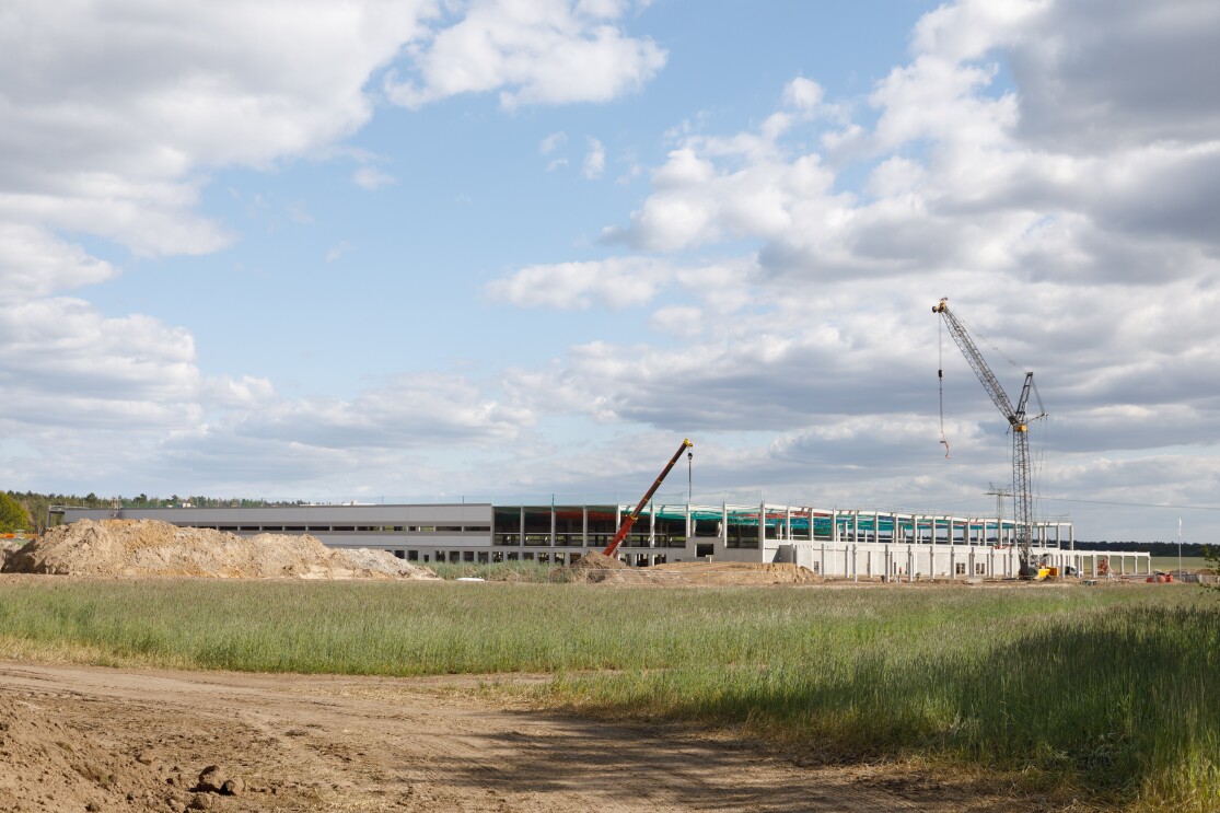 Ein flaches, großes Gebäude im Rohbau, Kräne sind zu sehen.