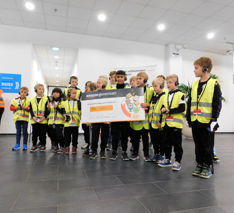 Eine Gruppe von Kindern, eines hält einen Spendenscheck
