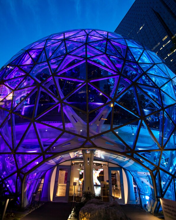 Amazon's Spheres buildings at night, lit up in Kraken blues and purples