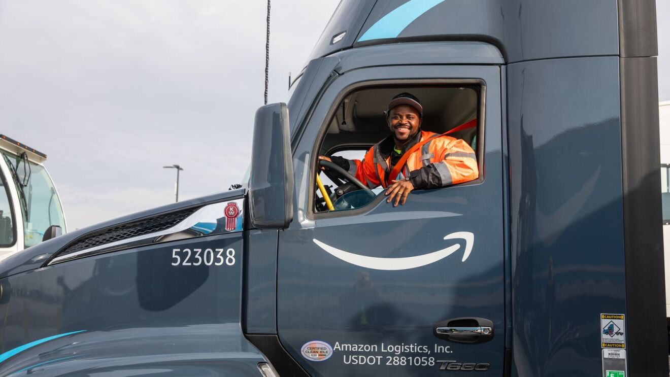 An image of Abel, an Amazon transportation team employee, in the driver's seat of a semi-trailer truck.