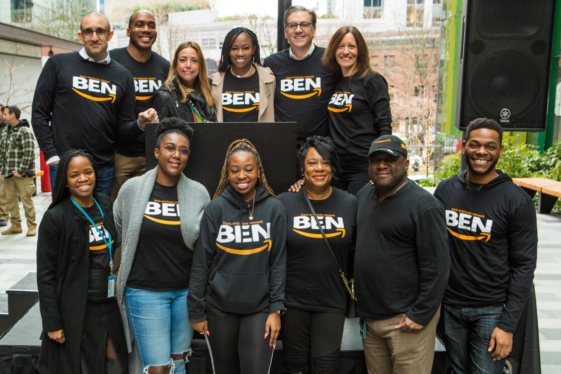 Members of the Black Employee Network stand for a photo on a podium on the steps of Amazon's Seattle headquarters.